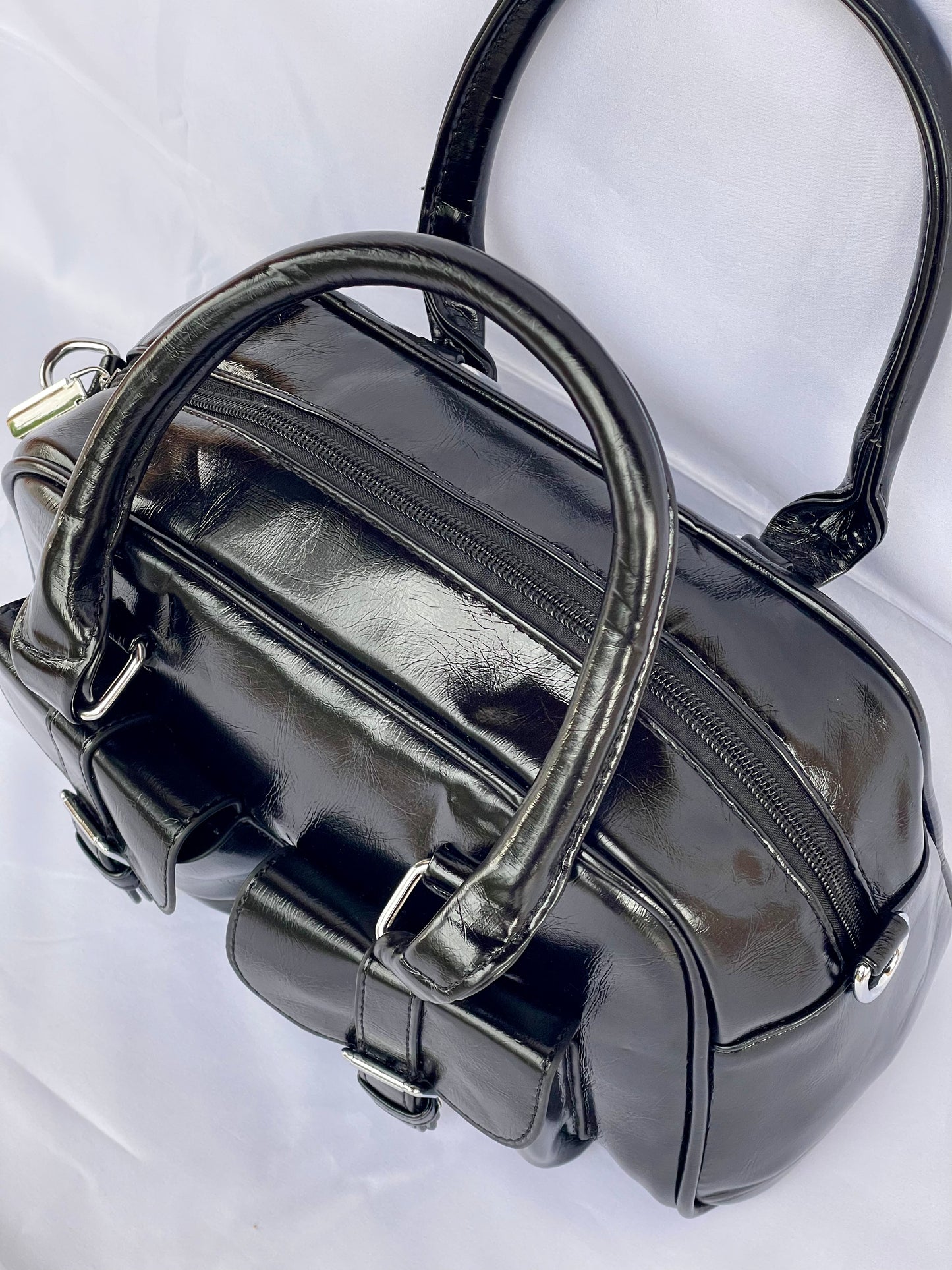 Borsa Bauletto Sydney nero lucido vista sui dettagli, manici e cerniera
