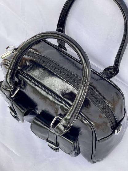 Borsa Bauletto Sydney nero lucido vista sui dettagli, manici e cerniera
