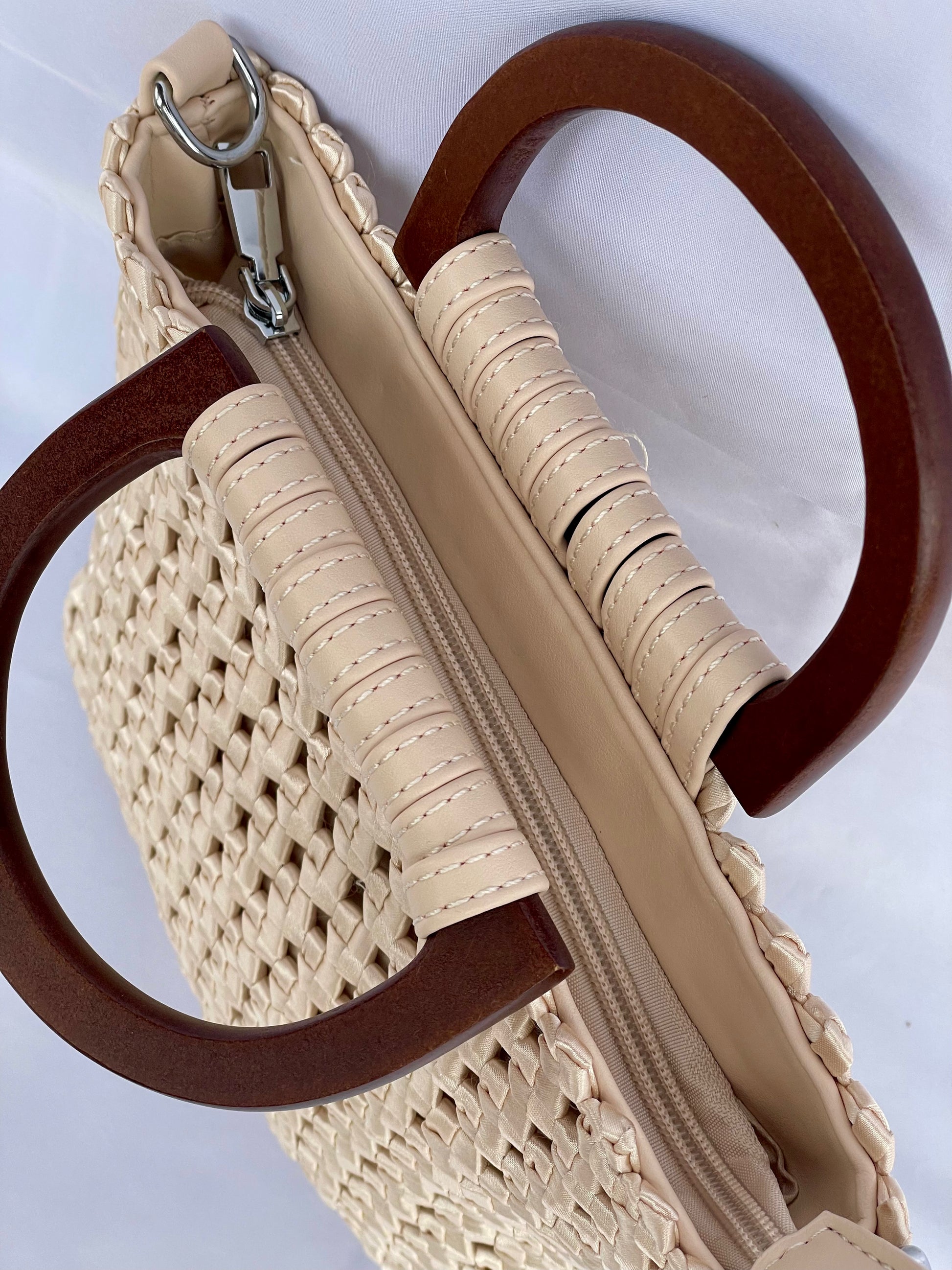 Borsa Cora intrecciata in tessuto con manici in legno vista su chiusura con zip